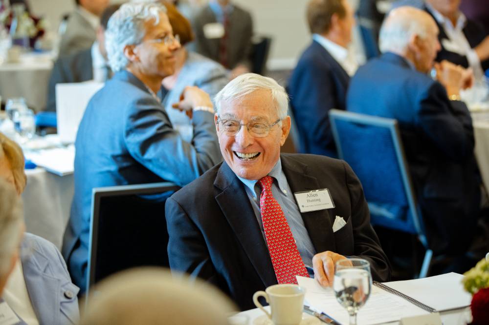 Guest sitting and laughing at the Foundation Annual Meeting
